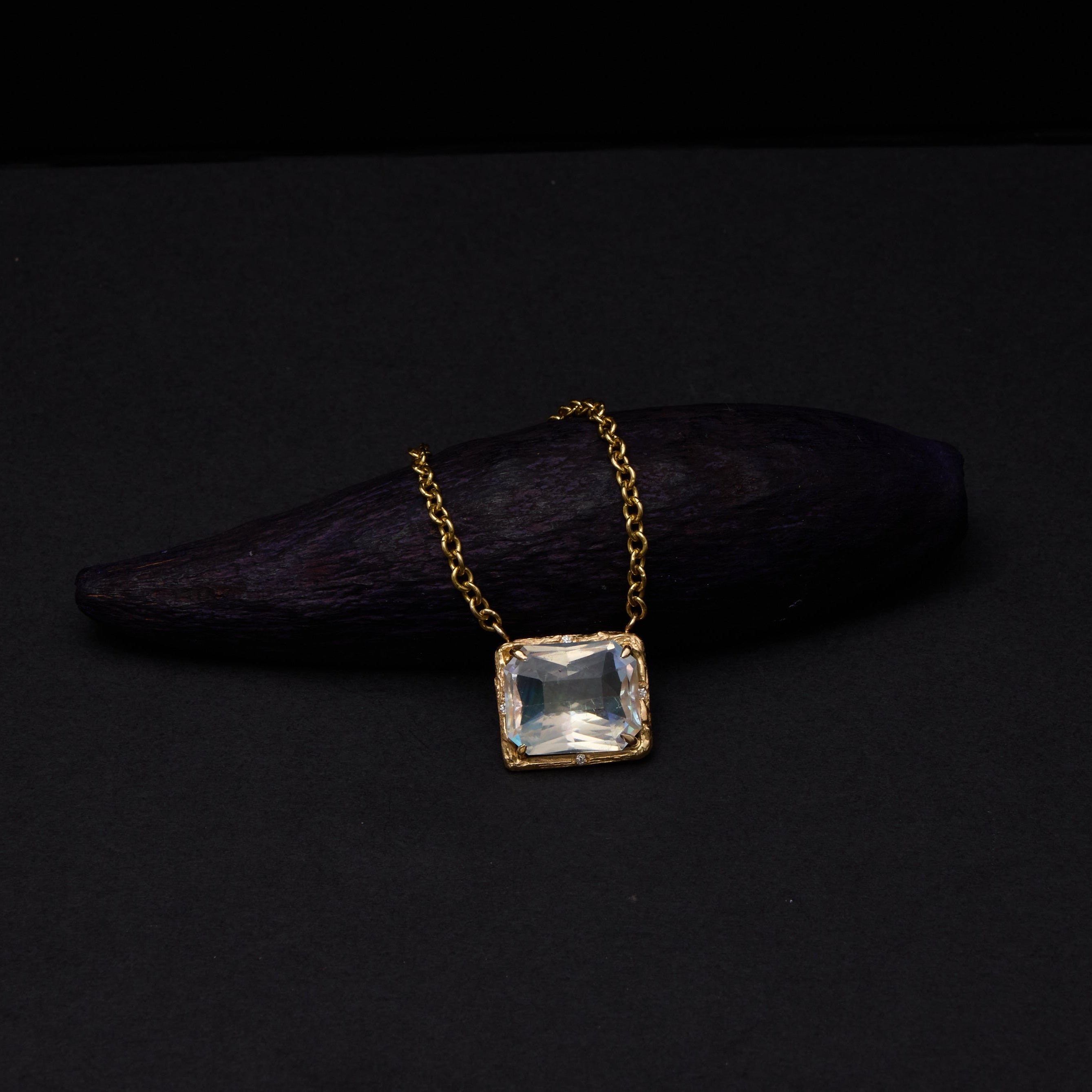 yellow gold moonstone necklace on dark background