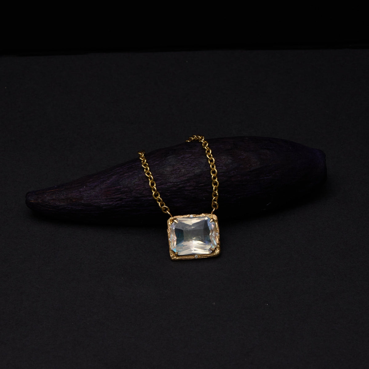 yellow gold moonstone necklace on dark background