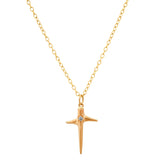 Gold cross necklace with a small diamond on a white background
