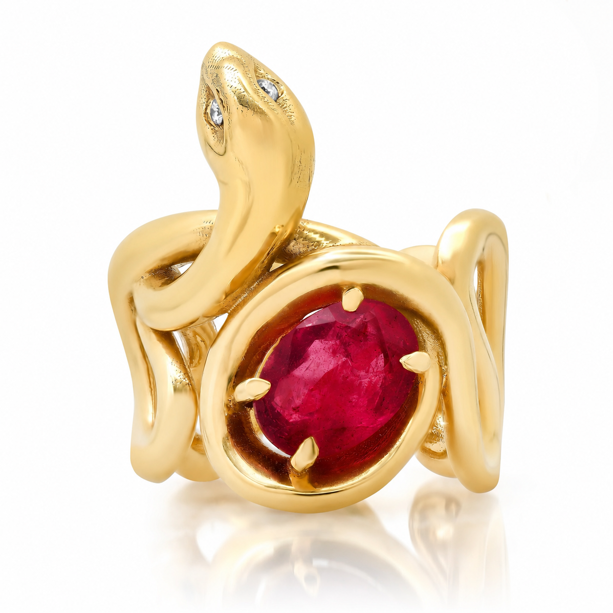 A gold snake ring with a large oval red ruby center stone and small diamond eyes, shown on a white background with a soft reflection.