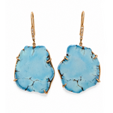 A pair of gold drop earrings featuring irregular, raw turquoise blue stone pendants with natural dark veining, suspended from gold hooks with small clear accent stones.