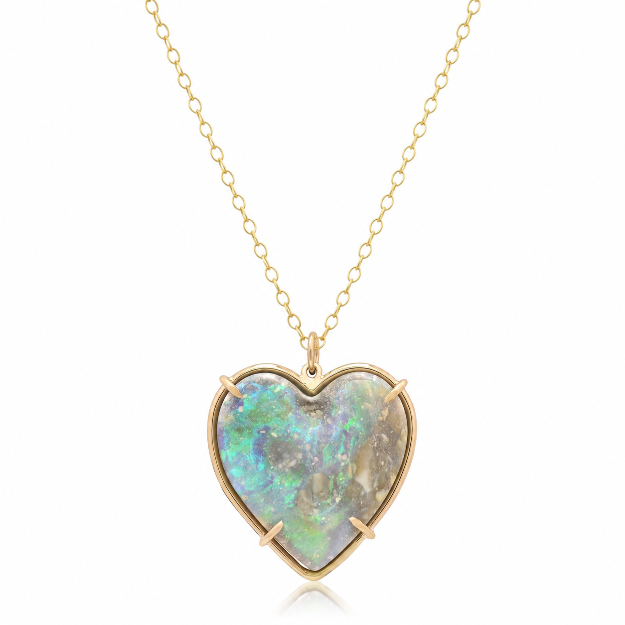 A heart-shaped pendant necklace featuring a vibrant iridescent opal gemstone in a gold bezel setting, suspended from a delicate gold chain against a clean white background.