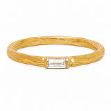 A textured yellow gold ring with a rectangular clear baguette-cut gemstone in the center, set against a plain white background.