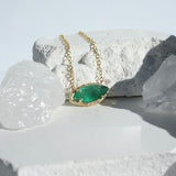 Brazilian Marquise Emerald Willow Necklace photographed on a white rock and crystal background