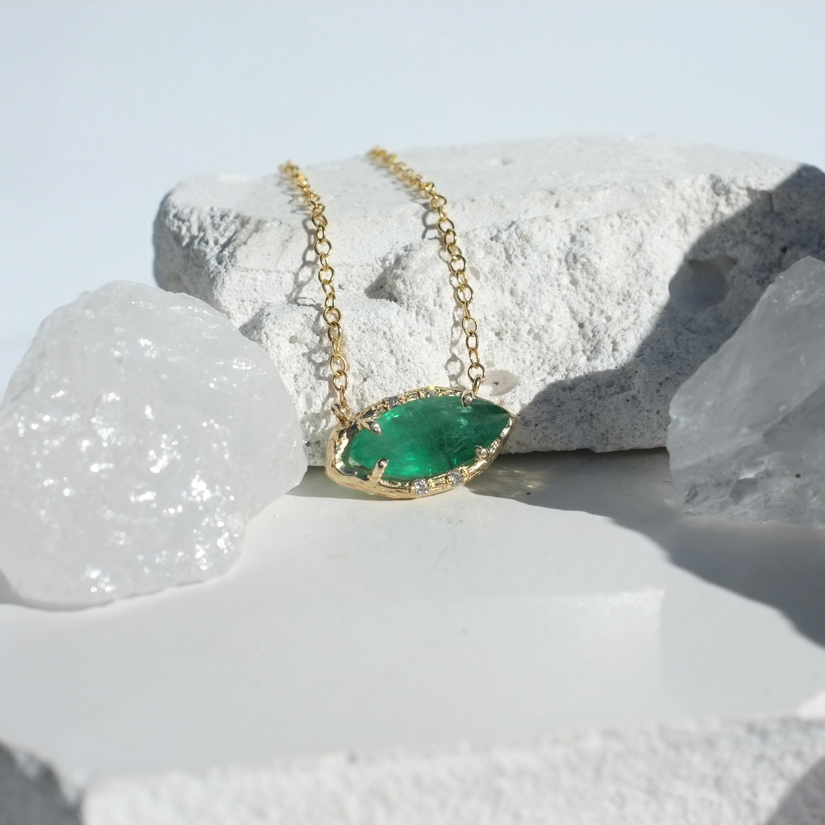 Brazilian Marquise Emerald Willow Necklace photographed on a white rock and crystal background