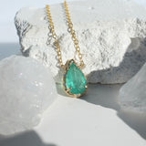 Brazilian Pear Emerald Willow Necklace photographed on a white background of rocks and crystals