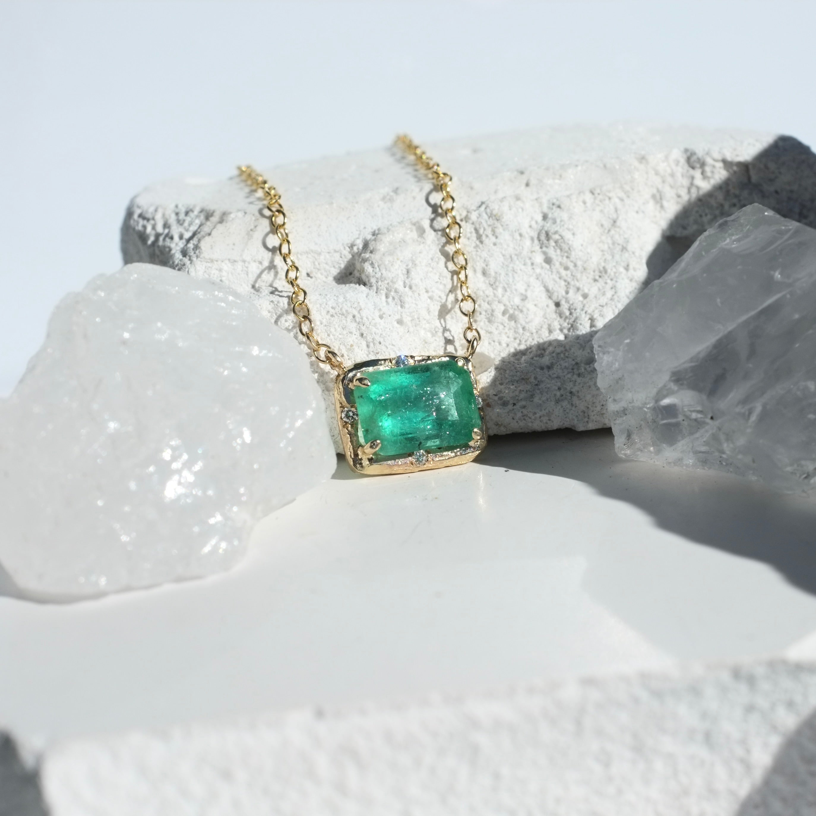 Brazilian Rectangular Emerald Willow Necklace photographed on a white background of crystals and rocks