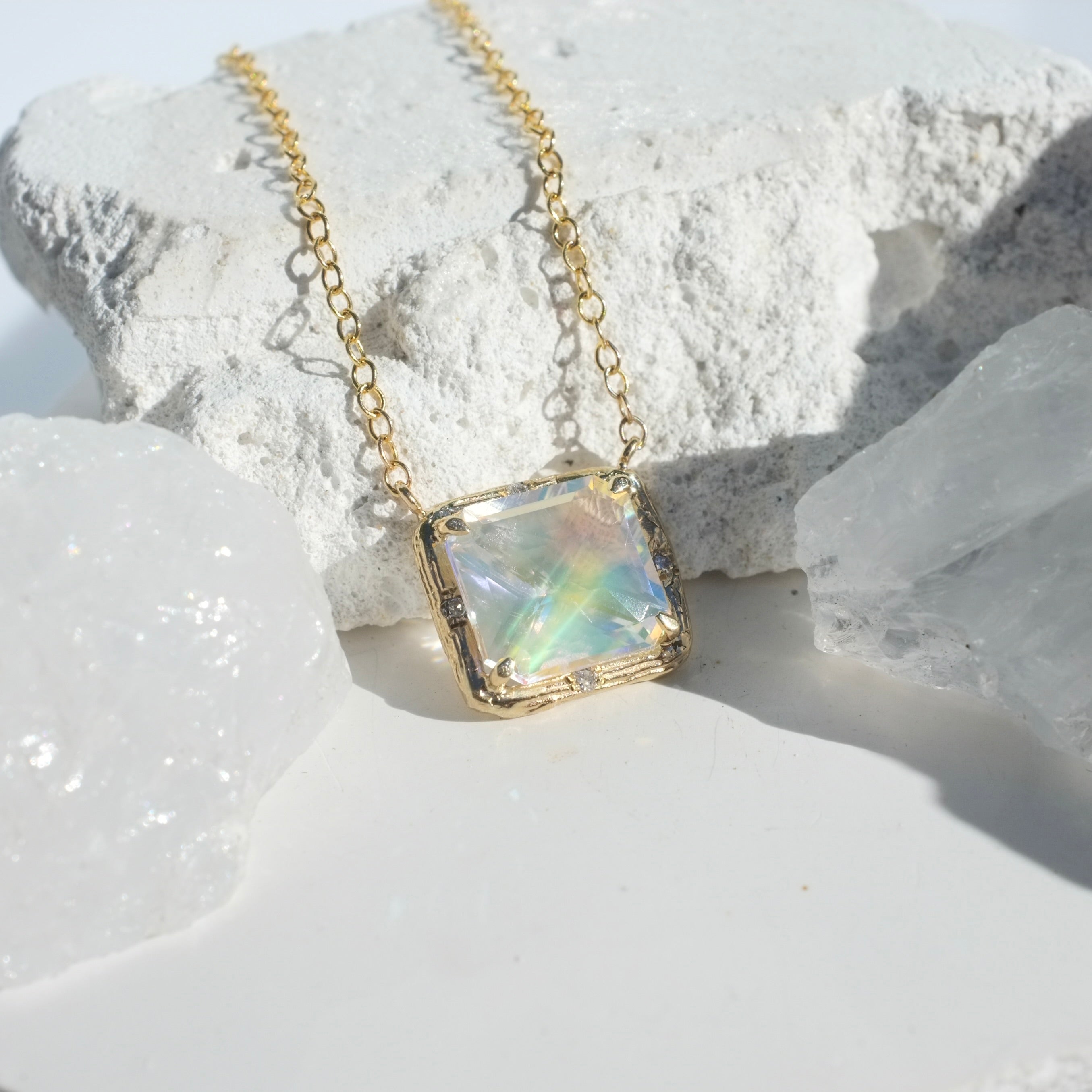Moonstone Willow Necklace photographed on a white background of rocks and crystals